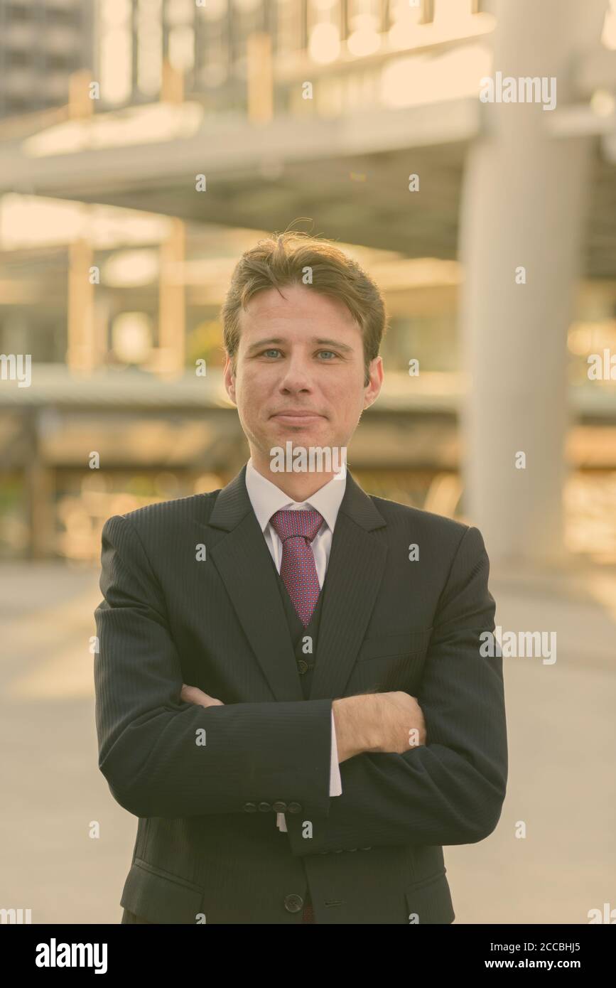 Businessman with arms crossed in front of modern building at Bangkok ...