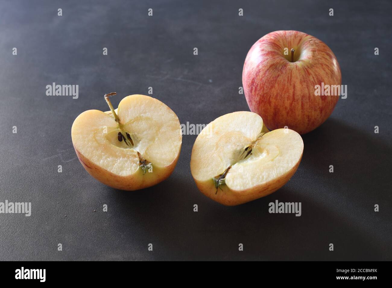 Apple cut in two halves and a full apple Stock Photo