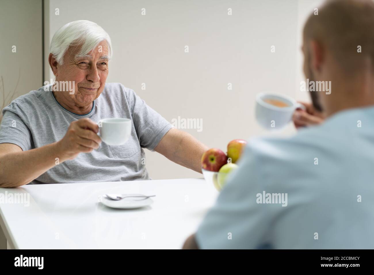 Caretaker In Retirement Home With Elder Man Stock Photo