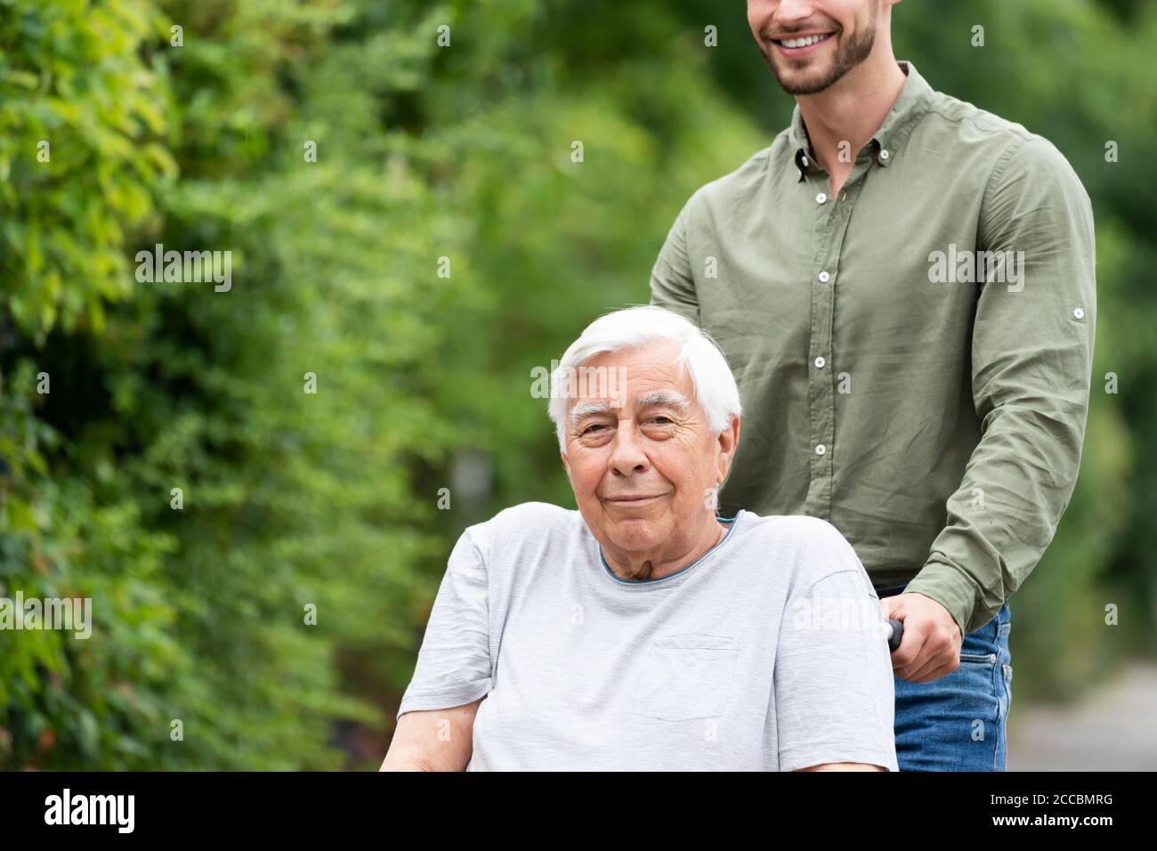 Old Smiling Senior Wheelchair Transport In Park Stock Photo Alamy