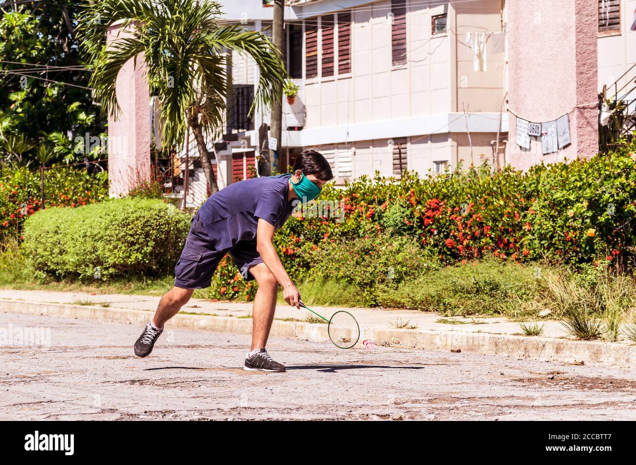 Young male during an informal badminton practice out in the street. Stock Photo