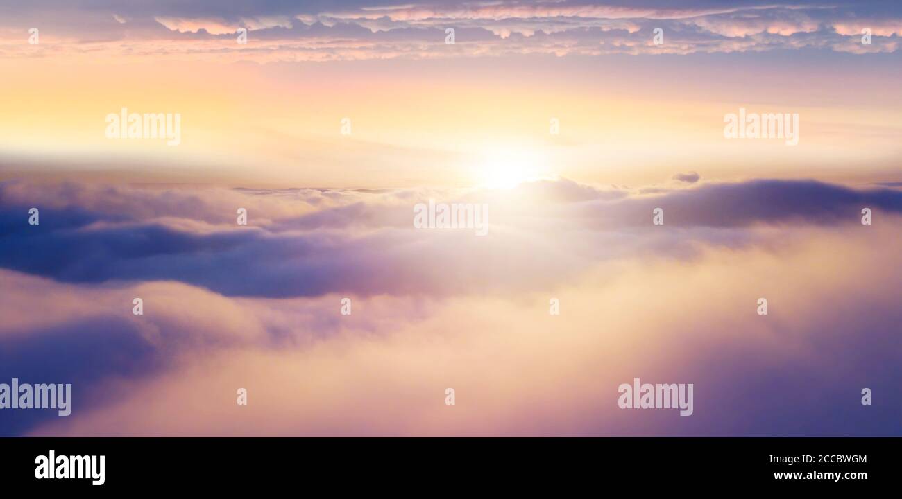 Beautiful sunset cloudy sky from aerial view. Airplane view above clouds Stock Photo