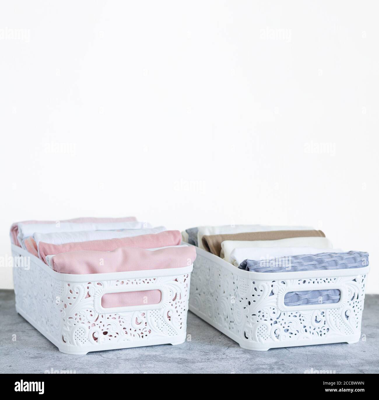 Two organizer boxes with pastel color clothes. Clothing neatly
