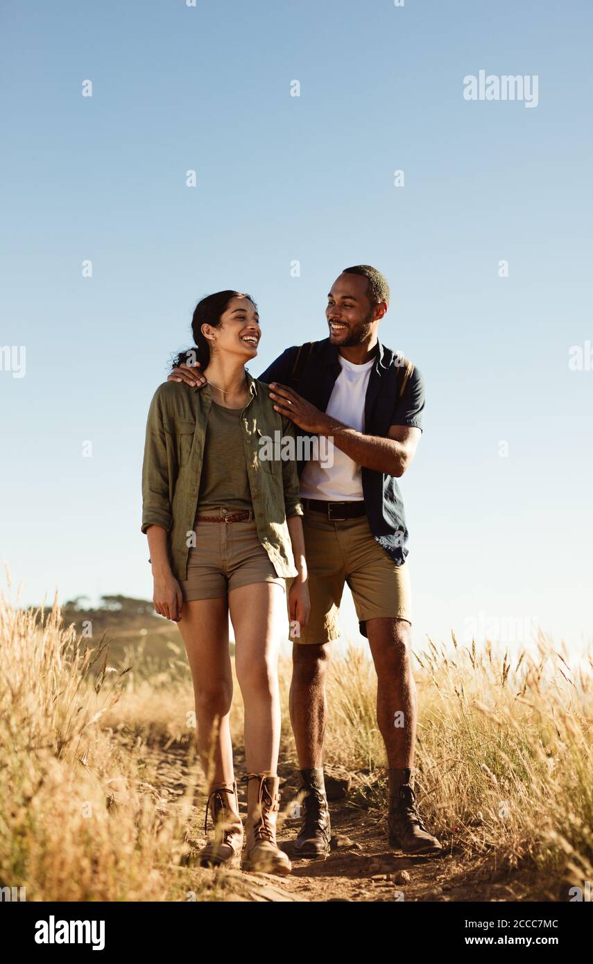 Portrait of a man and woman enjoying hiking. Cheerful couple walking together on a rugged hiking trail. Stock Photo