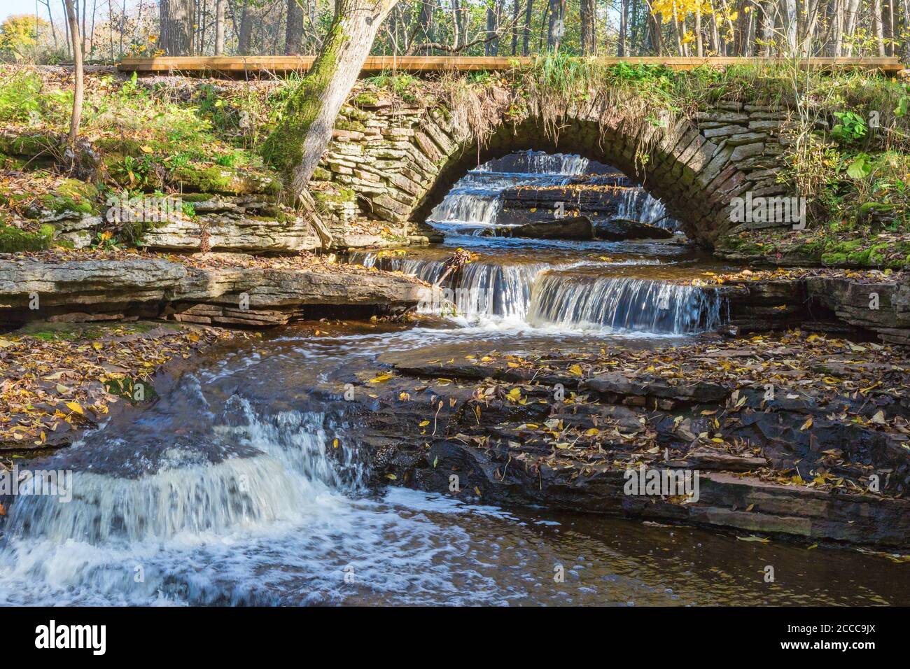 Old arch bridge over a stream with waterfalls Stock Photo - Alamy