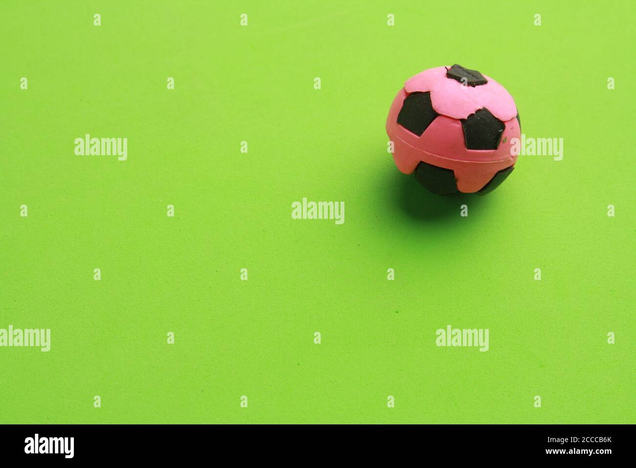 Closeup of a small rubber soccer ball toy on a green surface Stock