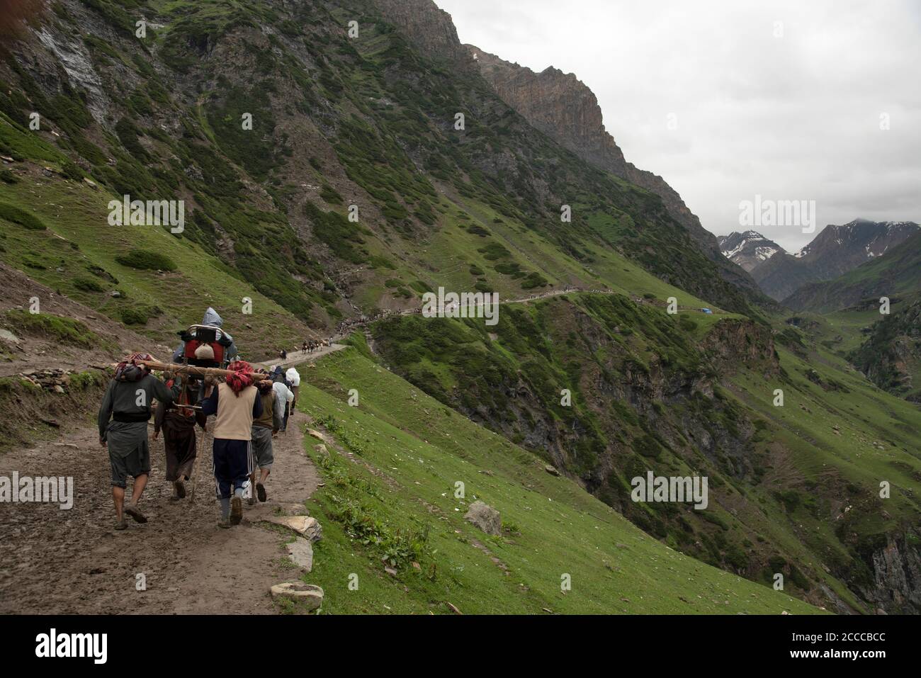 Service - Carrying old man by walking towards Tisu Top, Jammu Kashmir, India Stock Photo