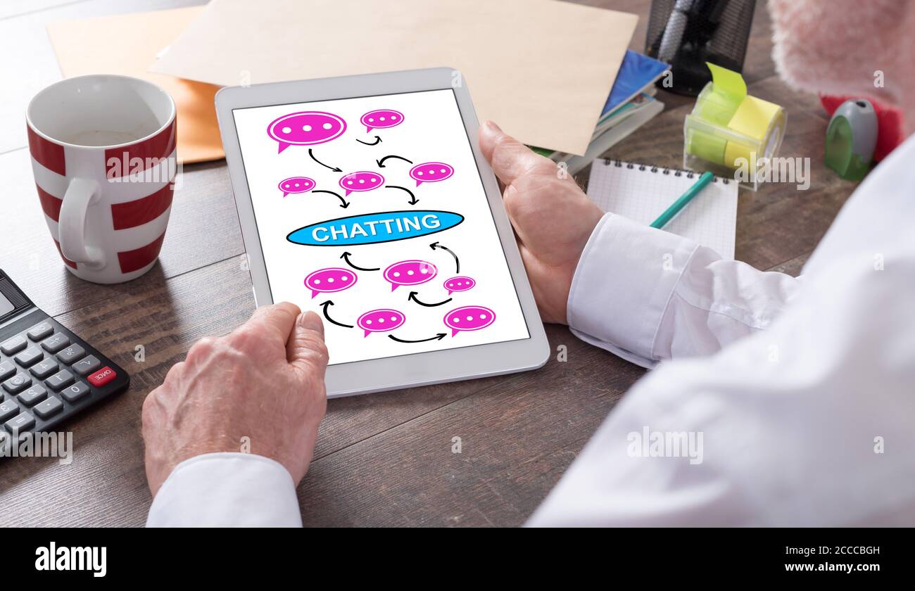 Chatting concept shown on a tablet held by a man Stock Photo
