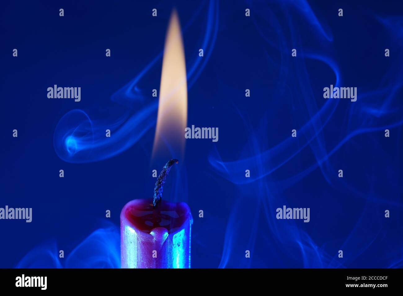 Closeup of a burning candle on a dark blue background - great for