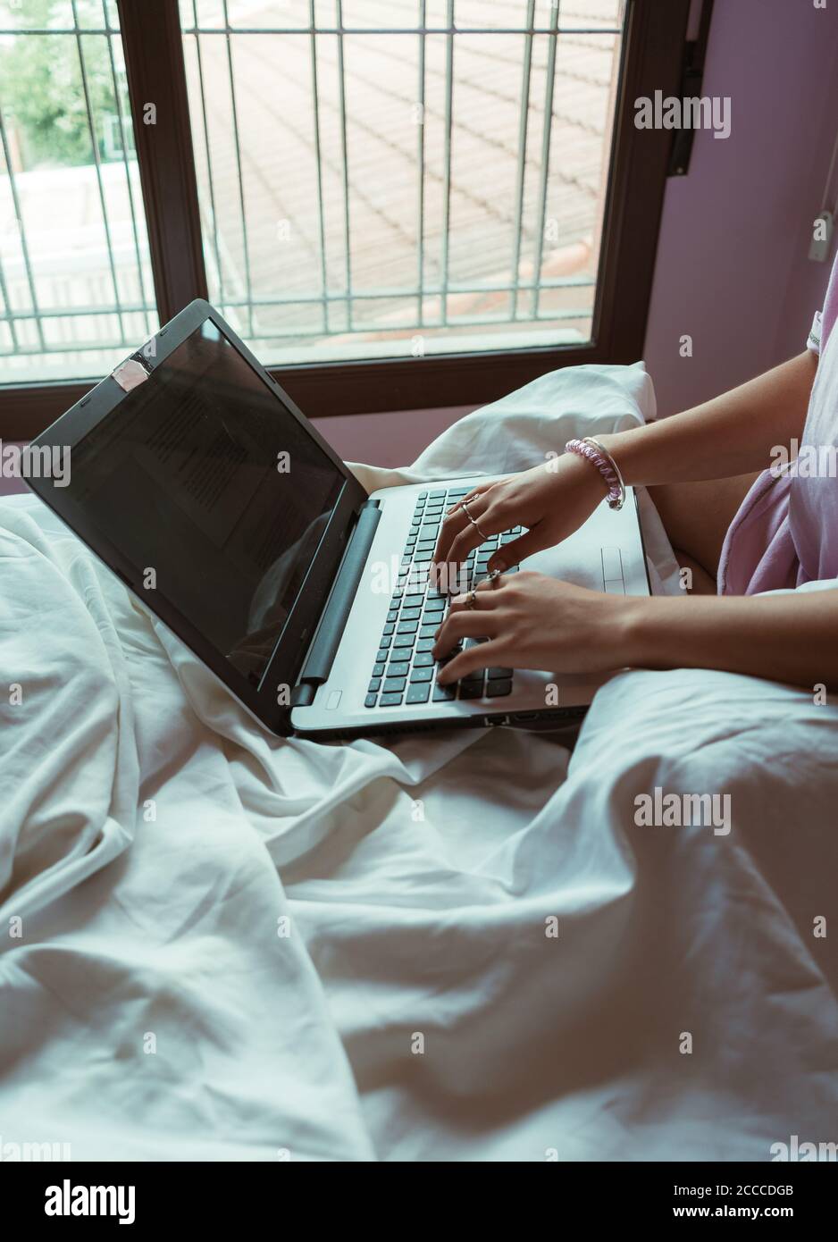 Photo of an an unrecognizable businesswoman sitting in her house working on her computer. Beautiful shot of an unrecognizable person's hands typing on Stock Photo