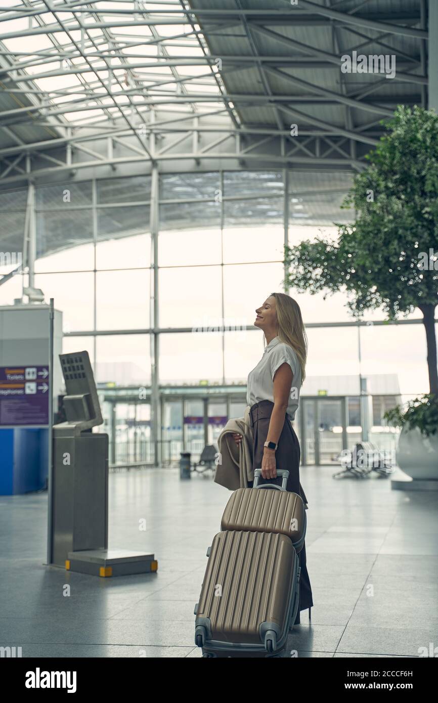 Young blonde woman checking time of her flight Stock Photo