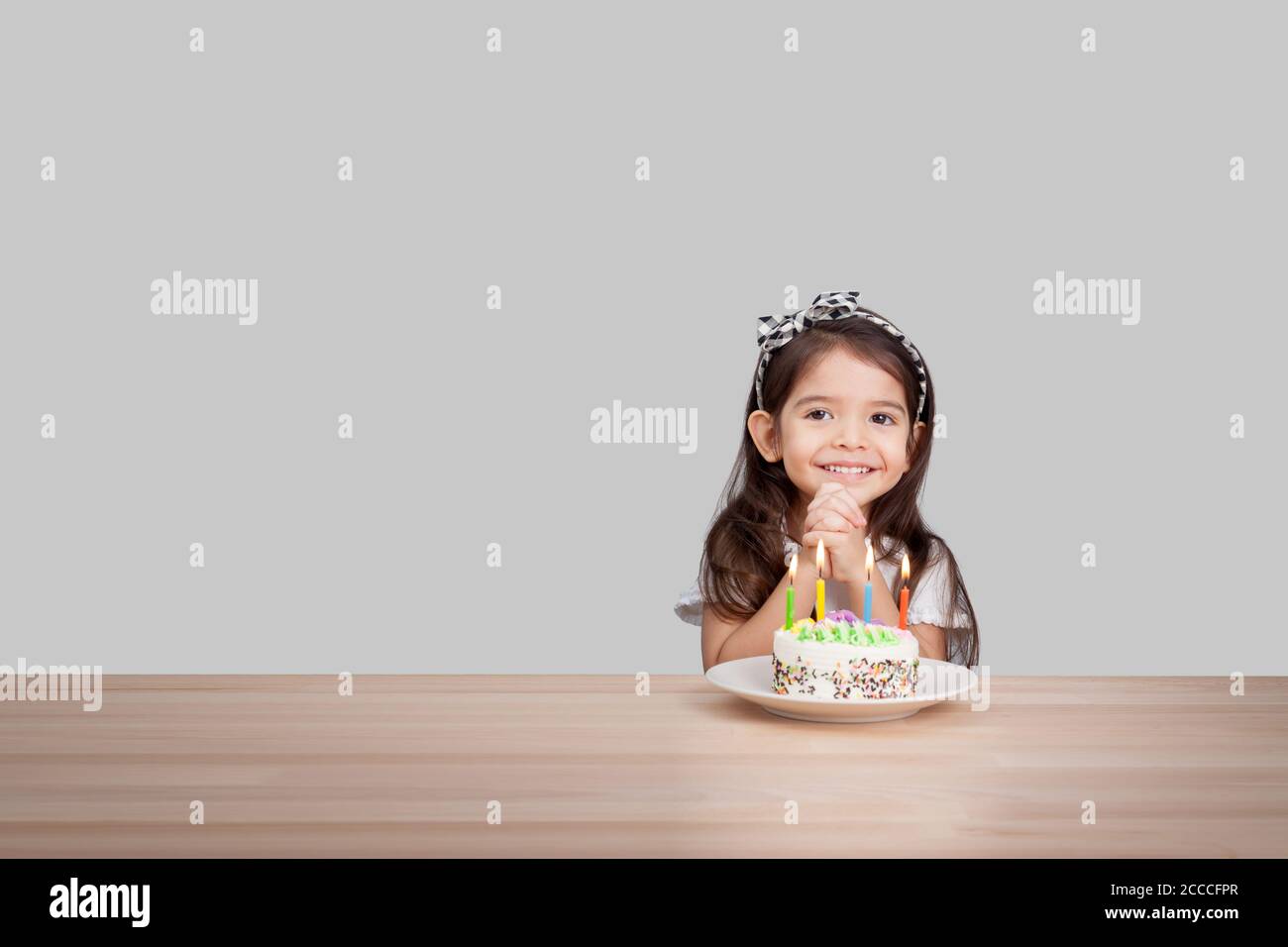 cute girl make a wish on birthday. Happy Birthday background. Greeting background for card, flyer, poster, sign, banner, web, postcard, invitation. Stock Photo