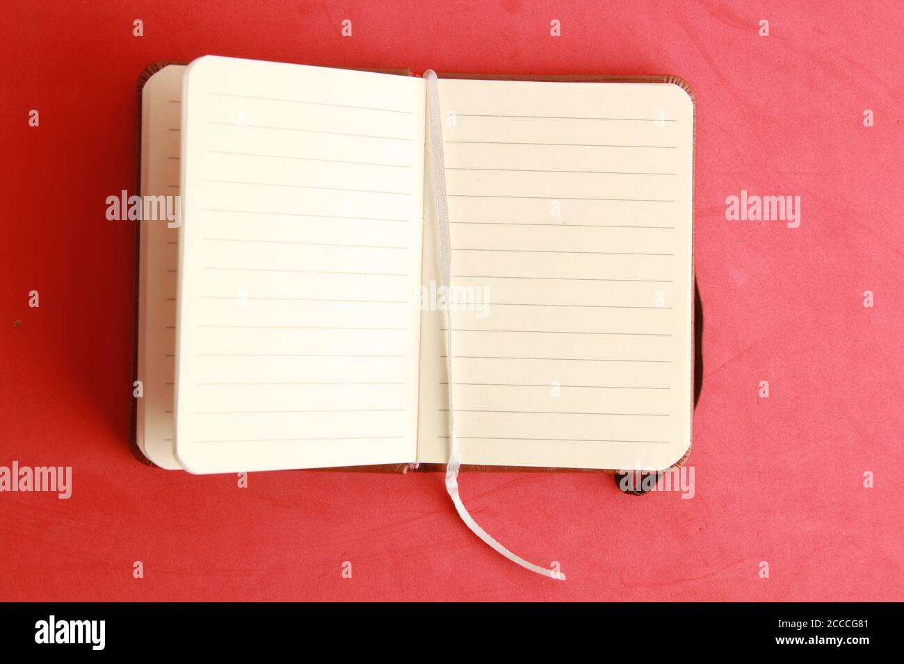 Open empty notebook on a red background Stock Photo
