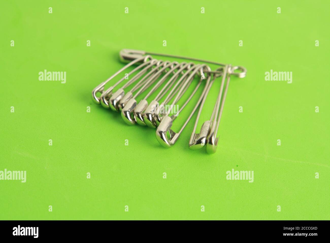 Set of sewing pins on a green surface Stock Photo Alamy