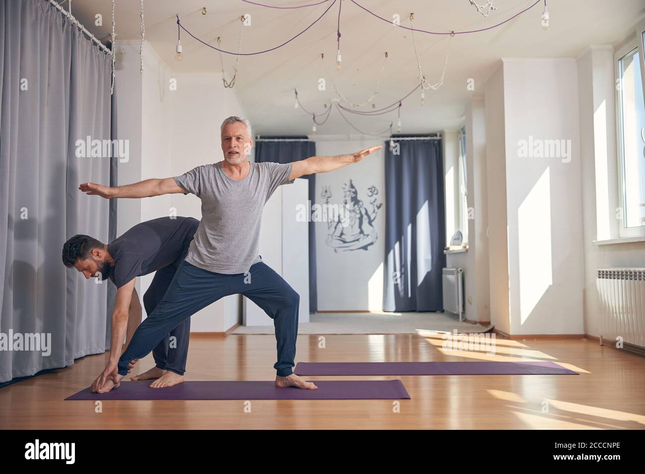 Beginner yogi practicing yoga in a gym Stock Photo