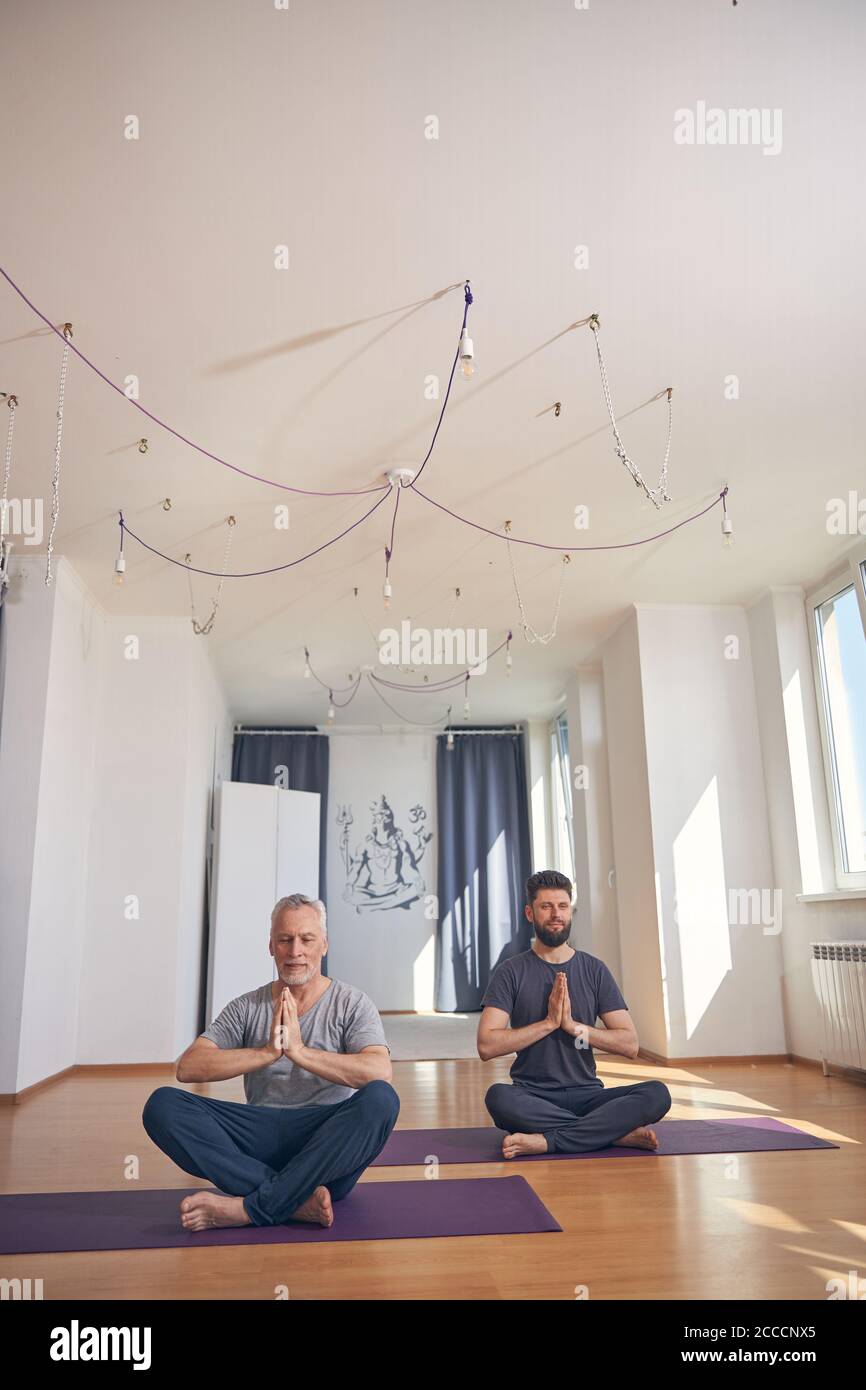 Two flexible men doing a lotus pose Stock Photo