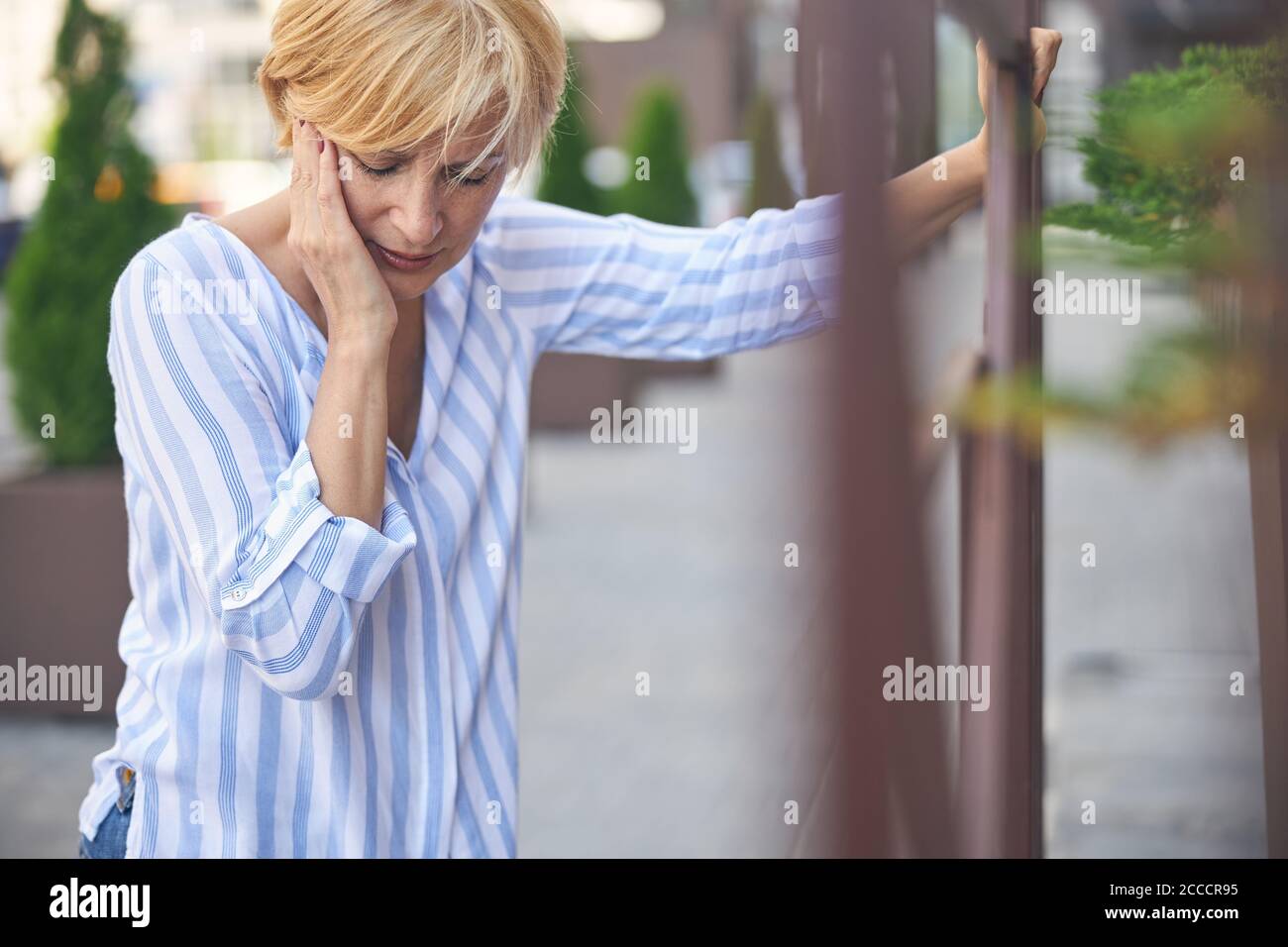 Mature blonde lady suffering from a toothache Stock Photo