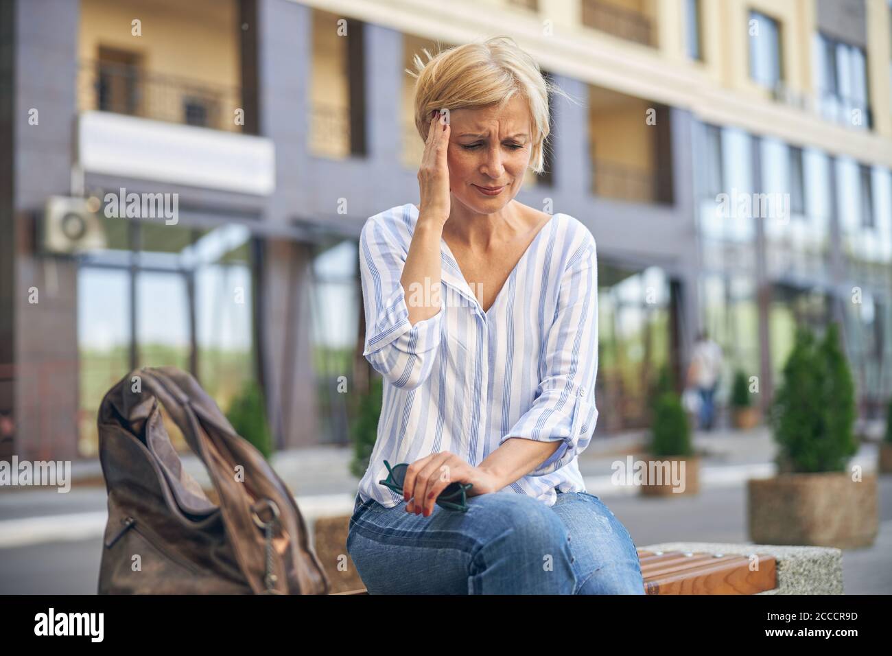 Sad blonde woman suffering from a headache Stock Photo