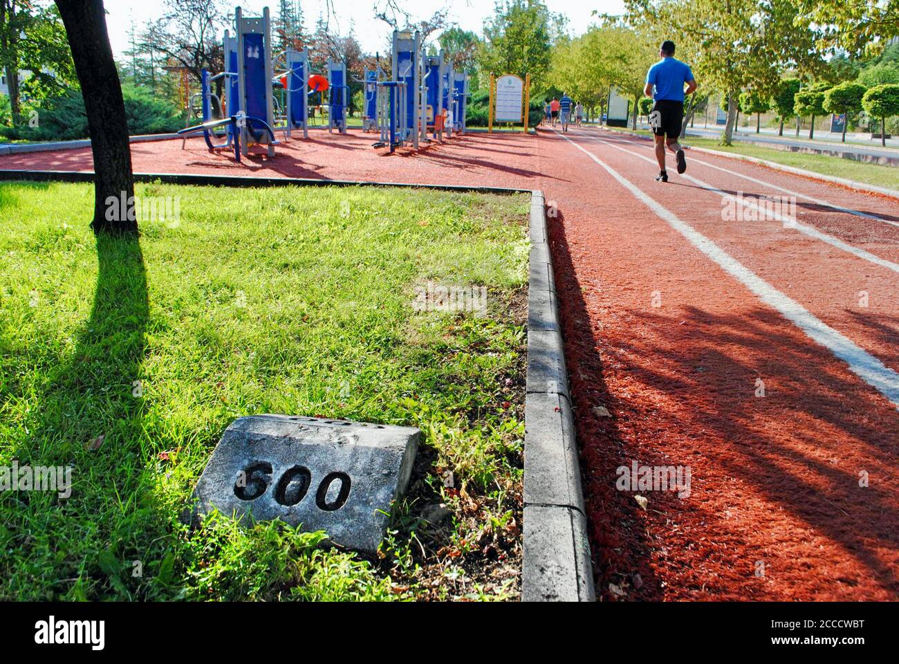 People running and walking on Track field with kilometer indicator on