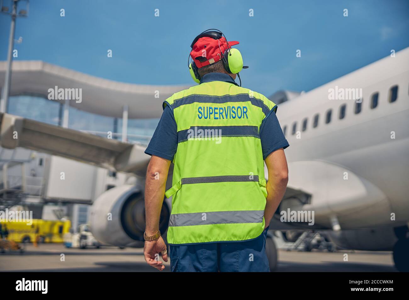 Airport worker looking at a parked plane Stock Photo Alamy