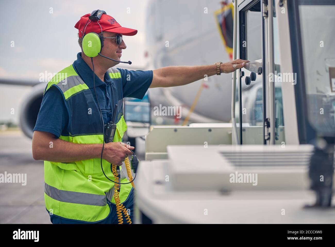 Airport worker standing in front of a pushback tug Stock Photo Alamy