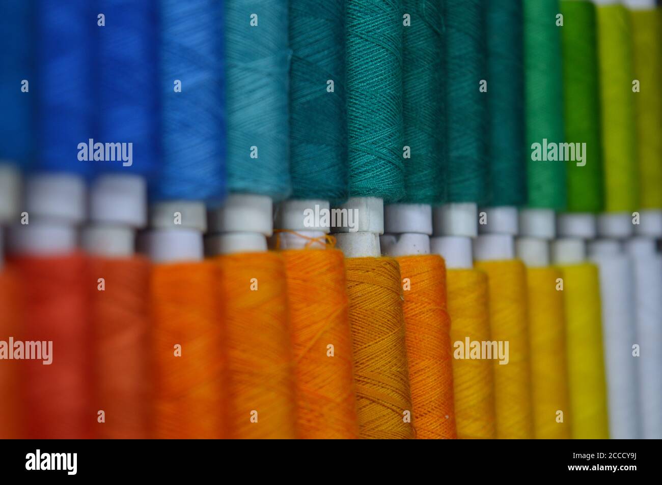 colourful thread rolls arranged in a box. Some parts of the image are ...