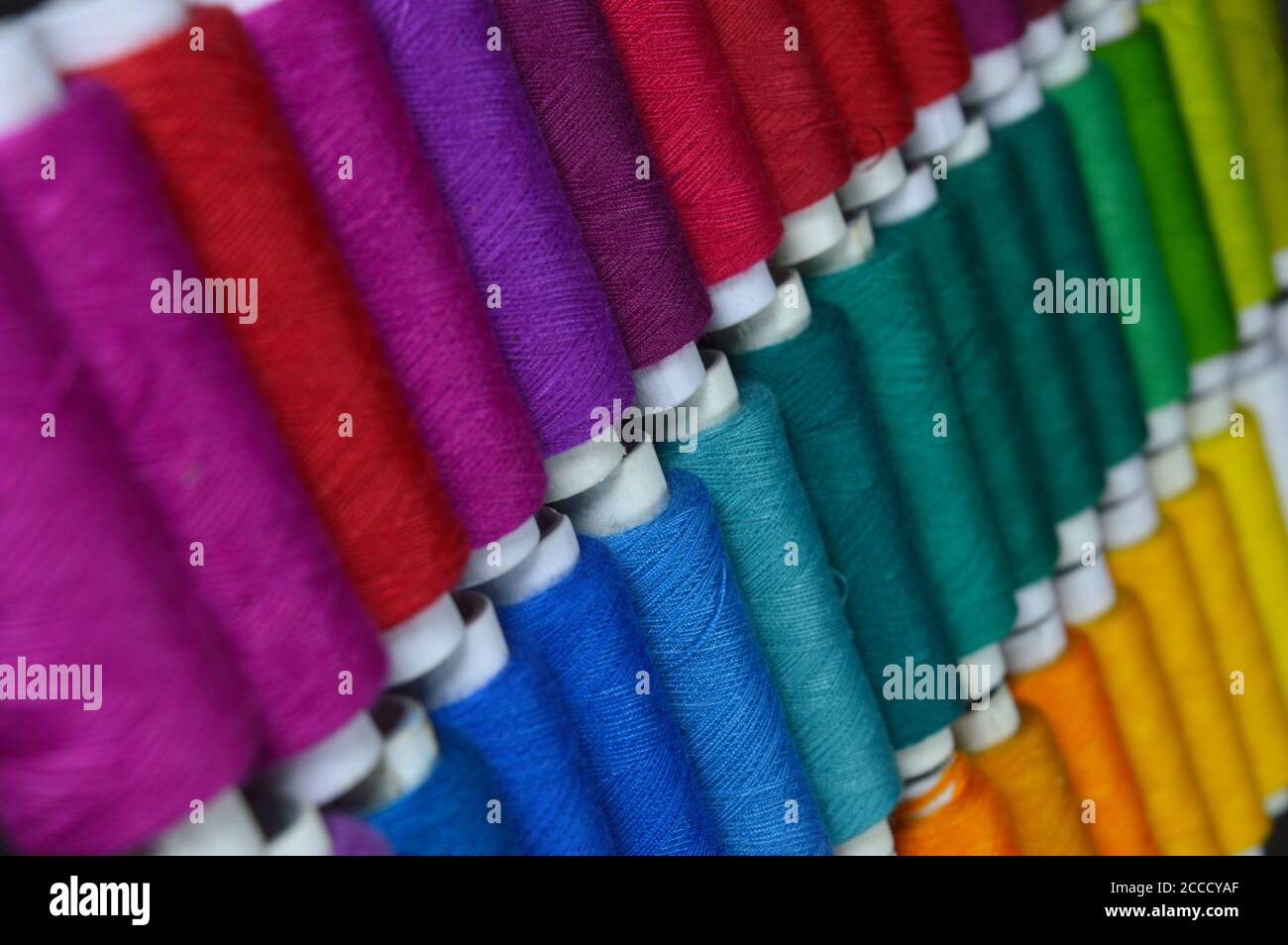 colourful thread rolls arranged in a box. Some parts of the image are ...