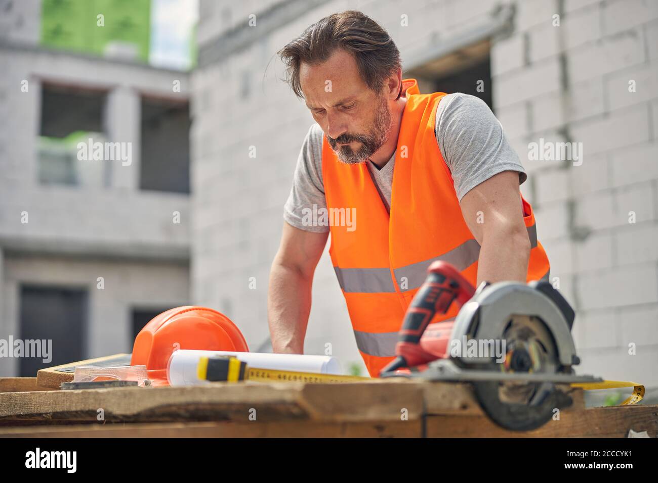 Concentrated serious civil engineer studying construction drawings Stock Photo