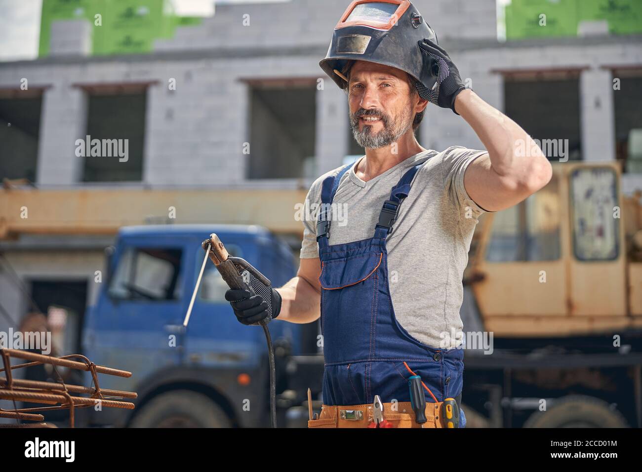 Male worker touching his safety helmet with one hand Stock Photo