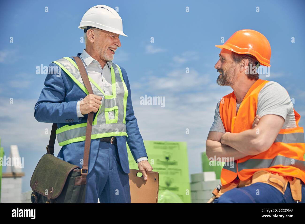 Merry senior man smiling at a construction worker Stock Photo