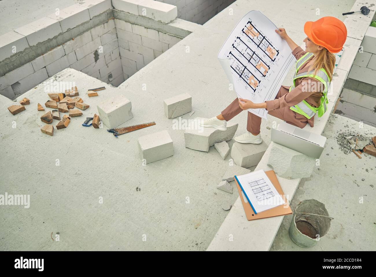 Concentrated lady analyzing technical drawings in her hands Stock Photo