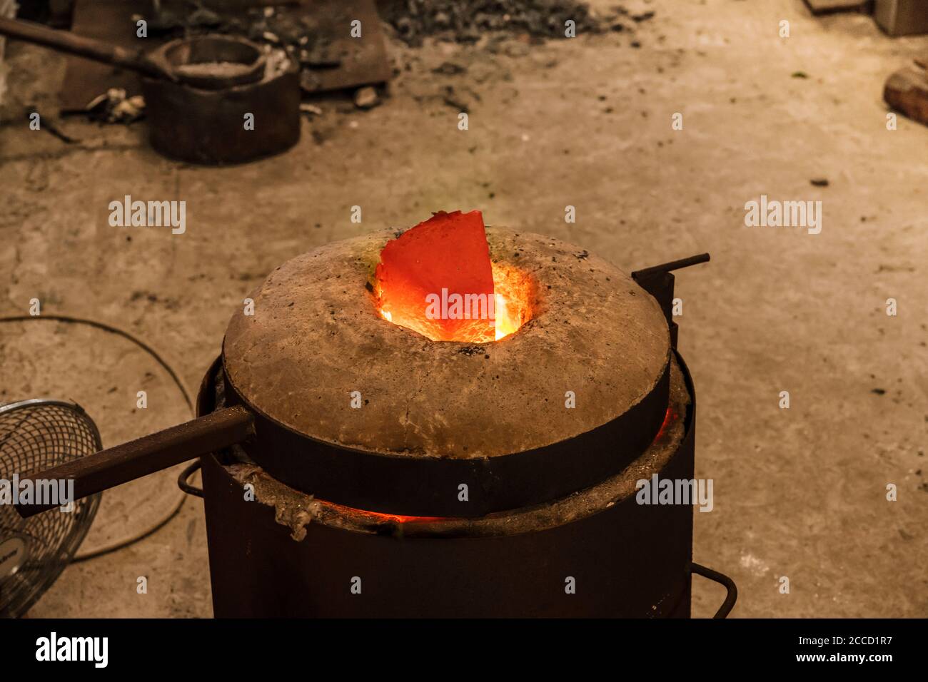 Casting the Bronze in small foundry. Sequence of images shows completely casting process from melting ingots to breaking ceramic shell of a sculpture. Stock Photo