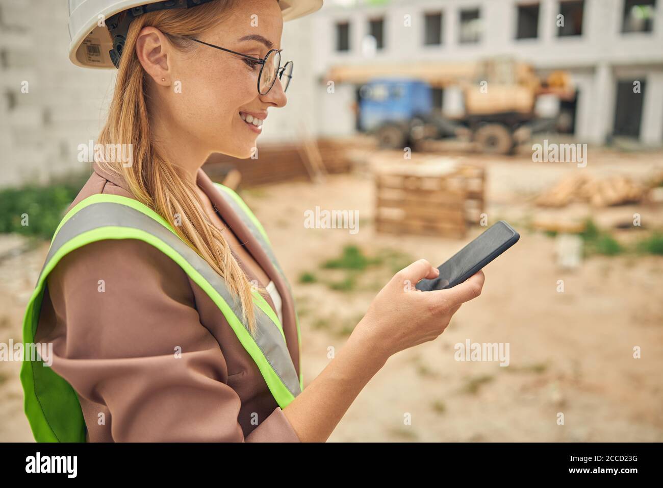 Contented young woman using her gadget outdoors Stock Photo