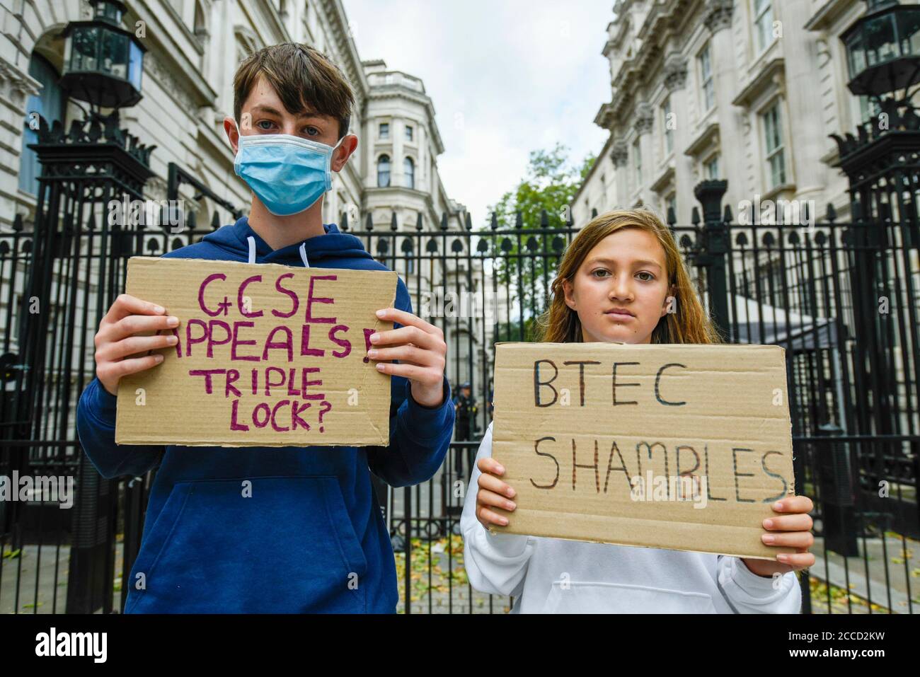 London, UK.  21 August 2020. GCSE and BTec student Tommy Walsh (L) (aged 16), supported by his sister Rosa (aged 11), join students protesting outside Downing Street calling for the resignation of Gavin Williamson, Secretary for Education, following this year’s exam results chaos.  After a successful campaign for A-Level and GCSE students to have grades based on teacher assessments rather than on a computer algorithm, BTec students will have to wait while exam board Pearson regrades their results.  (Parental permission obtained)  Credit: Stephen Chung / Alamy Live News Stock Photo