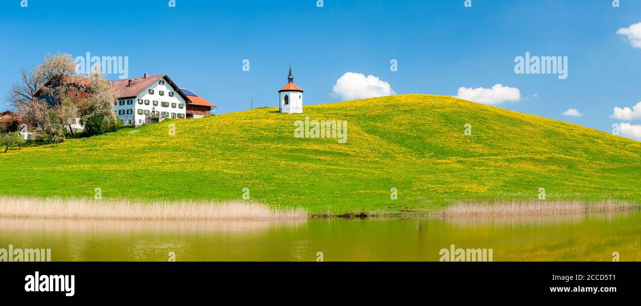 Panorama von Blumenwiese mit Bauernhof und Kapelle Stock Photo