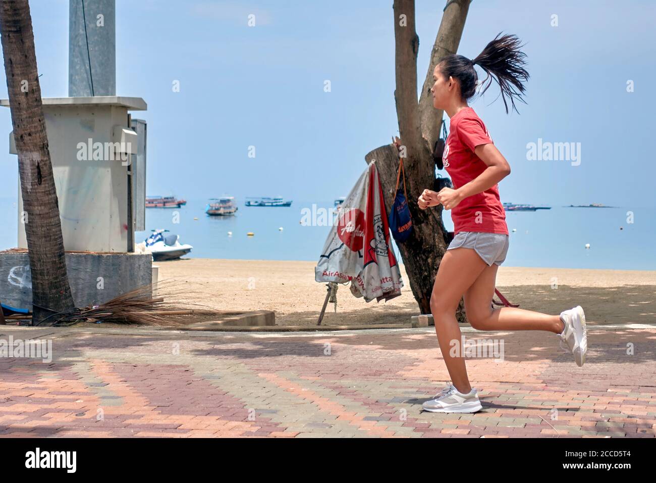 Woman running alongside the beach,  female keep fit exercise. People exercising. Thailand Southeast Asia Stock Photo