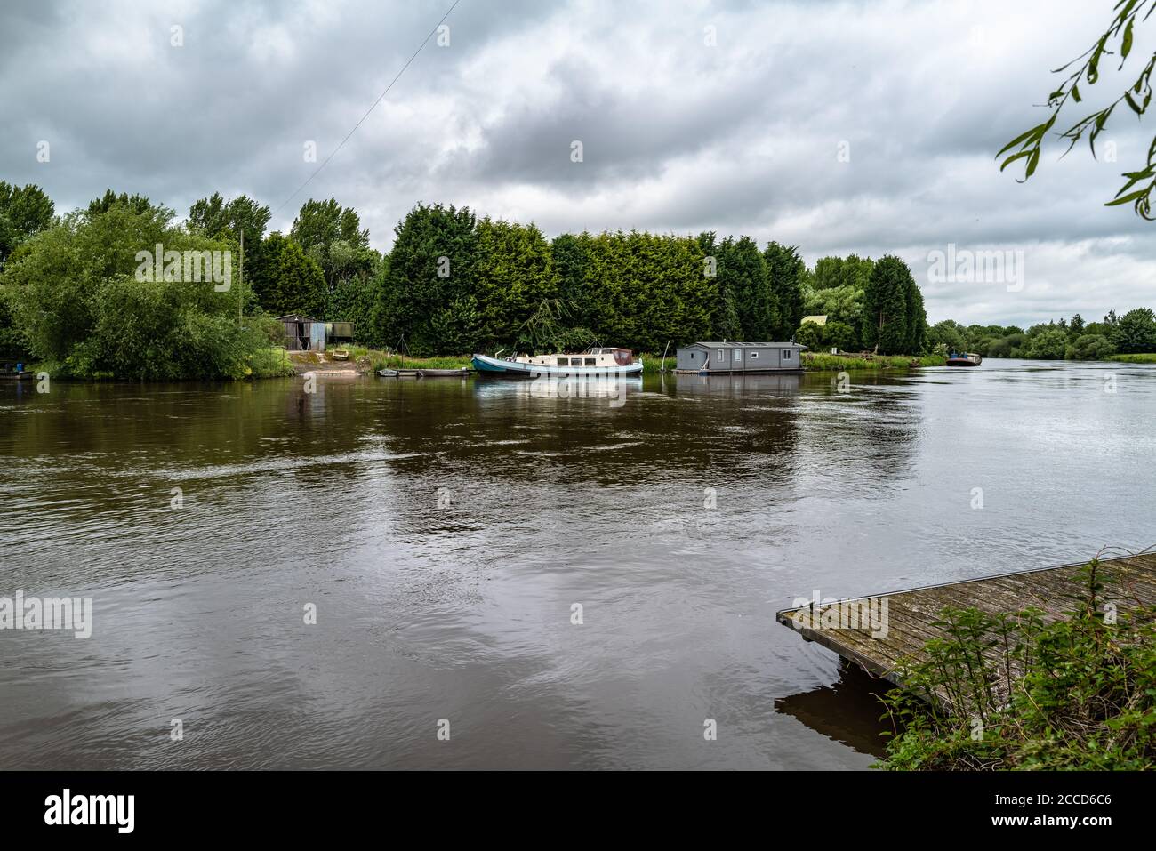 Looking across the River Trent at Farndon, in Nottinghamshire, towards an old boat slip and moored boats. Stock Photo