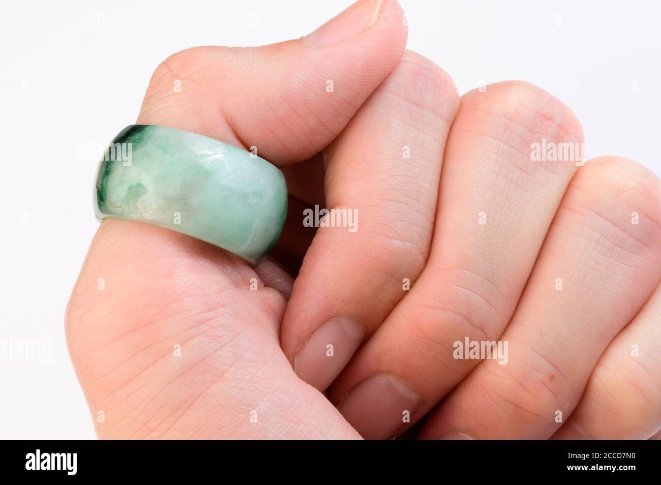 Green jade ring on thumb finger Stock Photo