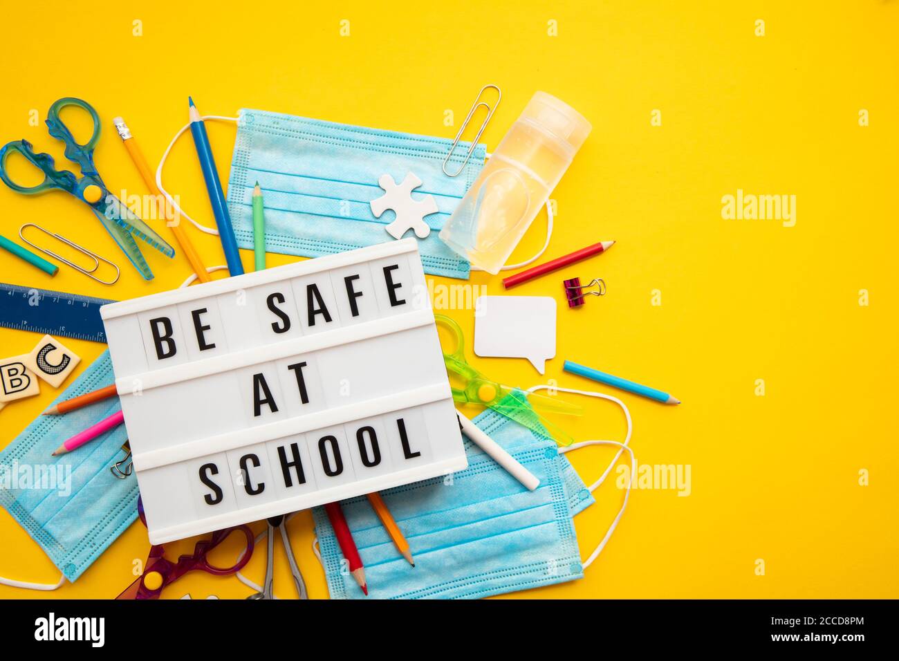 Be safe at school message with school equipment and covid masks Stock Photo