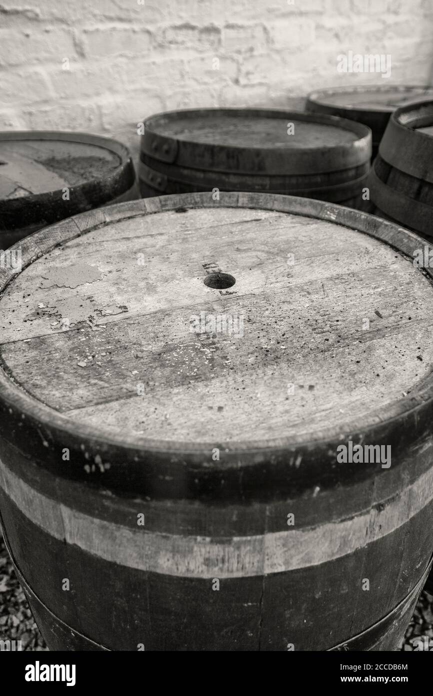 Old whisky barrels left outside to weather in the elements, black and white. Stock Photo