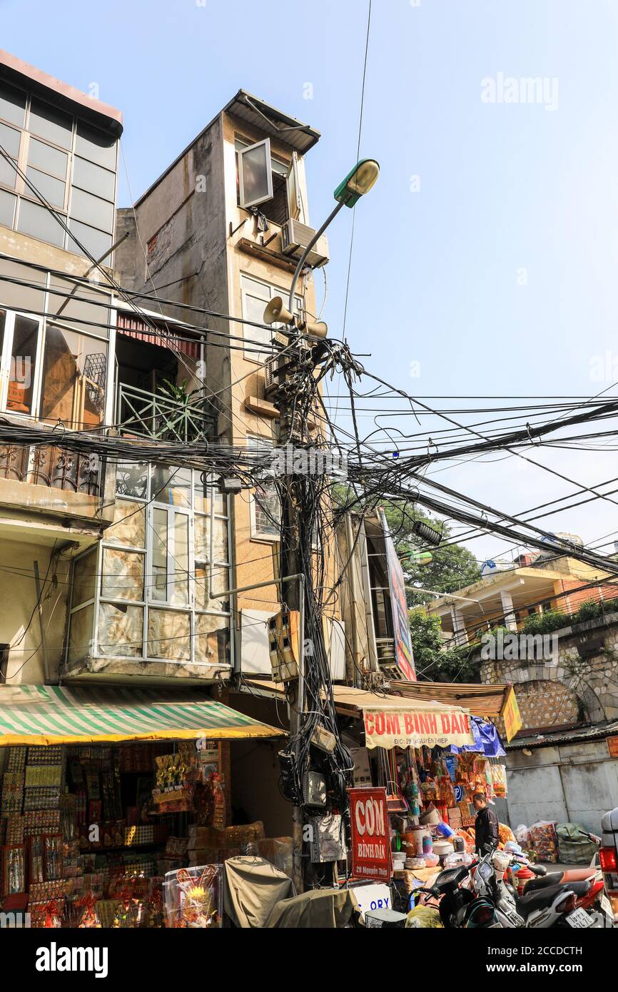 Lots of electrical wires on a street lamp on a street in Hanoi, Vietnam