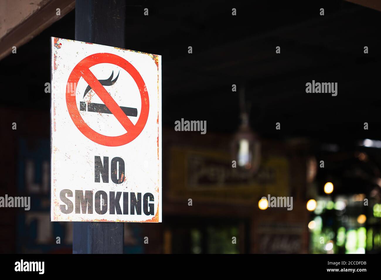 Close up of a grunge rustry No Smoking sign, outdoor infront of a restaurant background, selective focus. Stock Photo