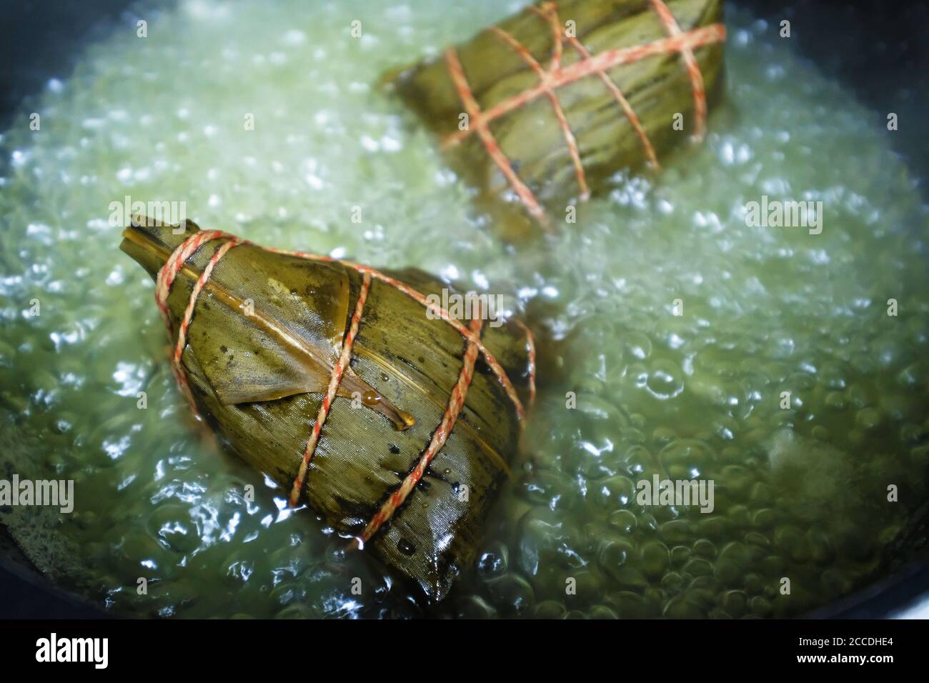 Close up rice dumpling (zongzi) in boiling water. Traditional Chinese food in Dragon Boat Festival. Stock Photo