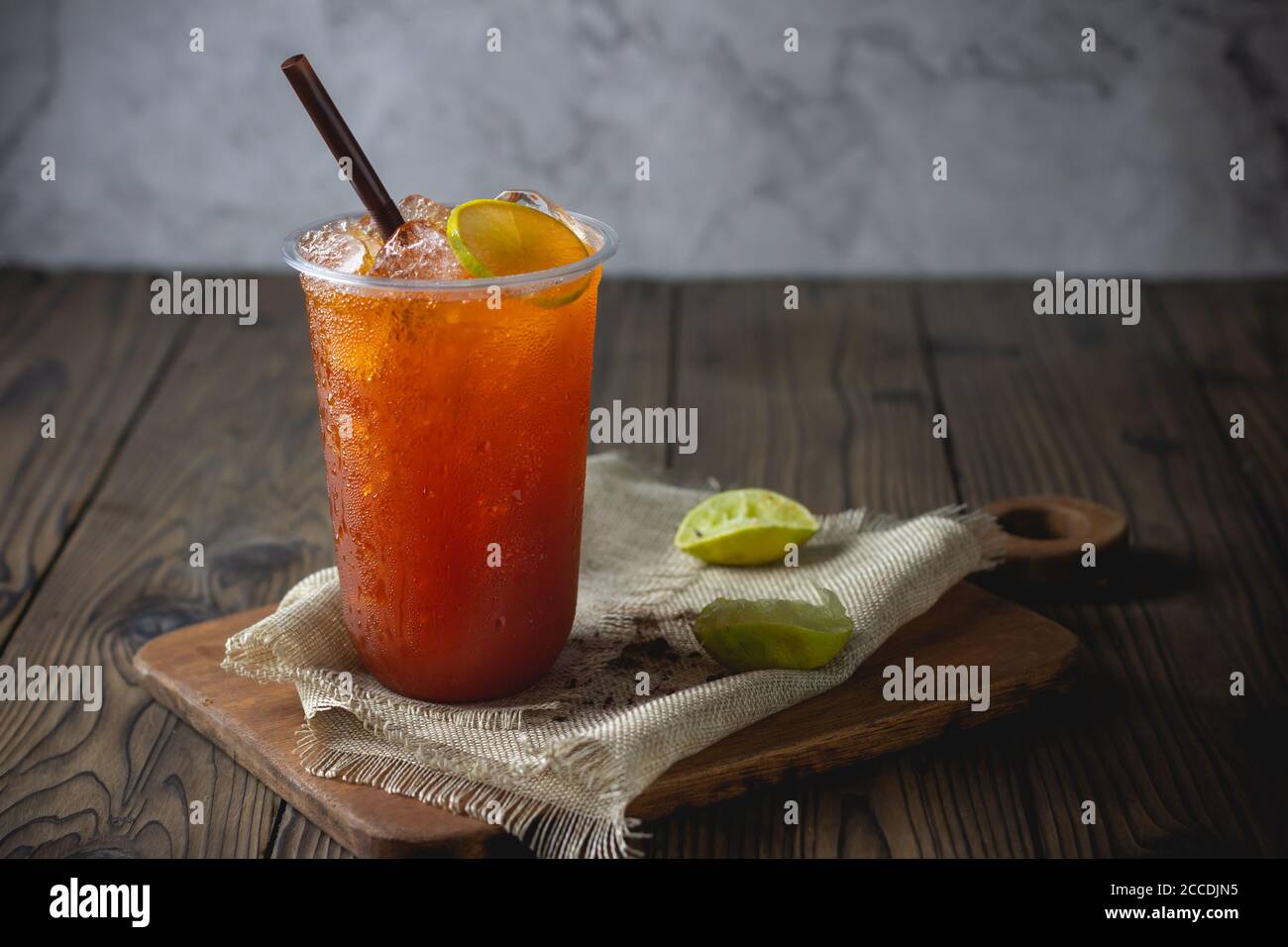 https://c8.alamy.com/comp/2CCDJN5/ice-tea-with-slice-of-lemon-in-plastic-cup-on-the-wooden-background-2CCDJN5.jpg