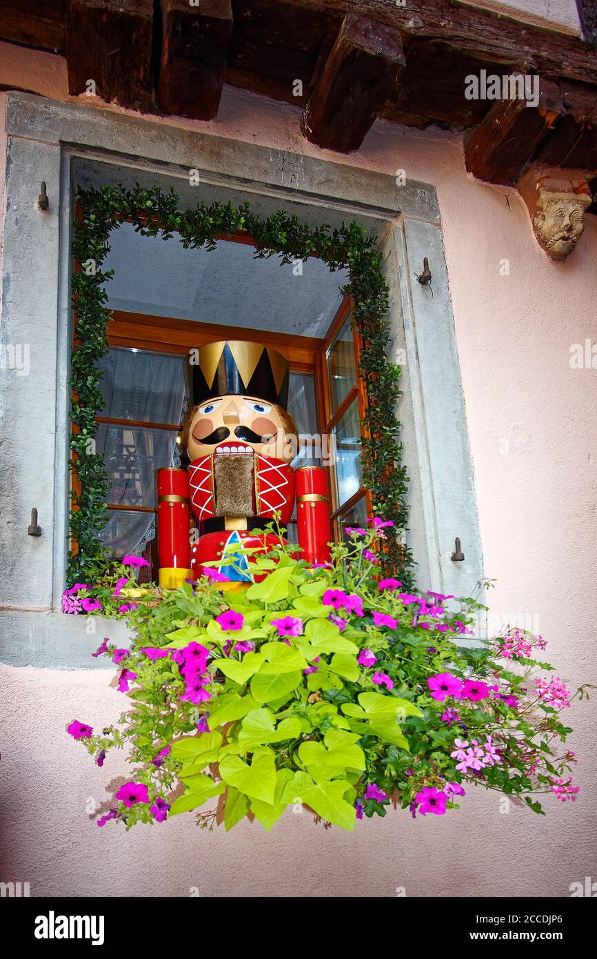 window, old  building, toy soldier figure, flowers, vine, unique, fortified village; 15-18 centuries; Europe; Alsace; Riquewihr; France Stock Photo
