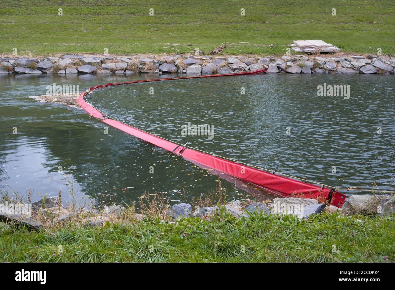 Plastic boom in the river. Barrier and obstacle contain and prevent spreading of pollution, contamination, toxicity and dirtiness in the water. Obstac Stock Photo