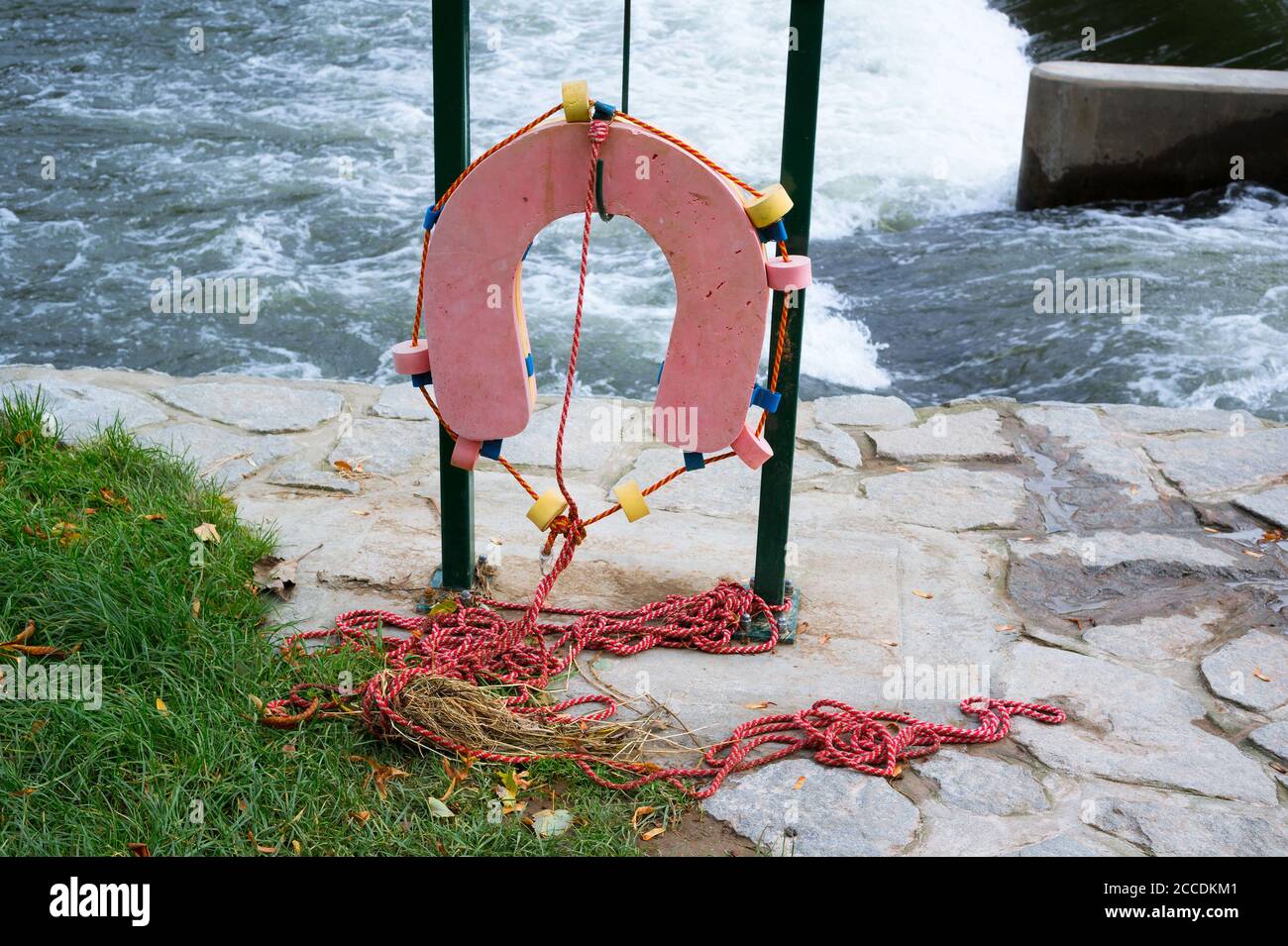 Lifesaver device on the bank to save and rescue drown person. Water in the background. Stock Photo