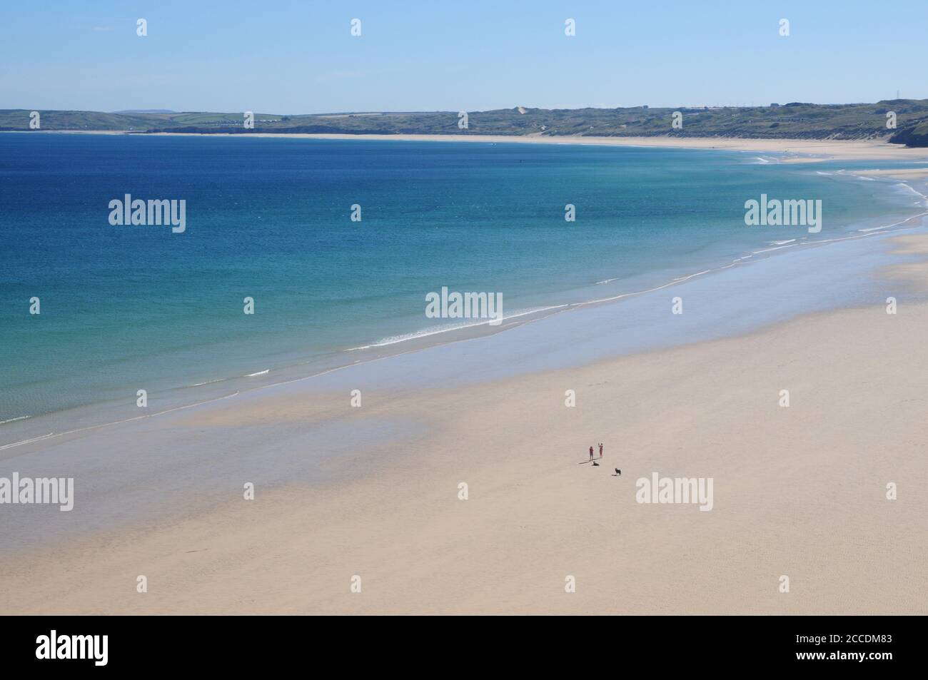 Early morning dog walkers on Porth Kidney Sands, between Carbis Bay and Lelant in north Cornwall. Stock Photo