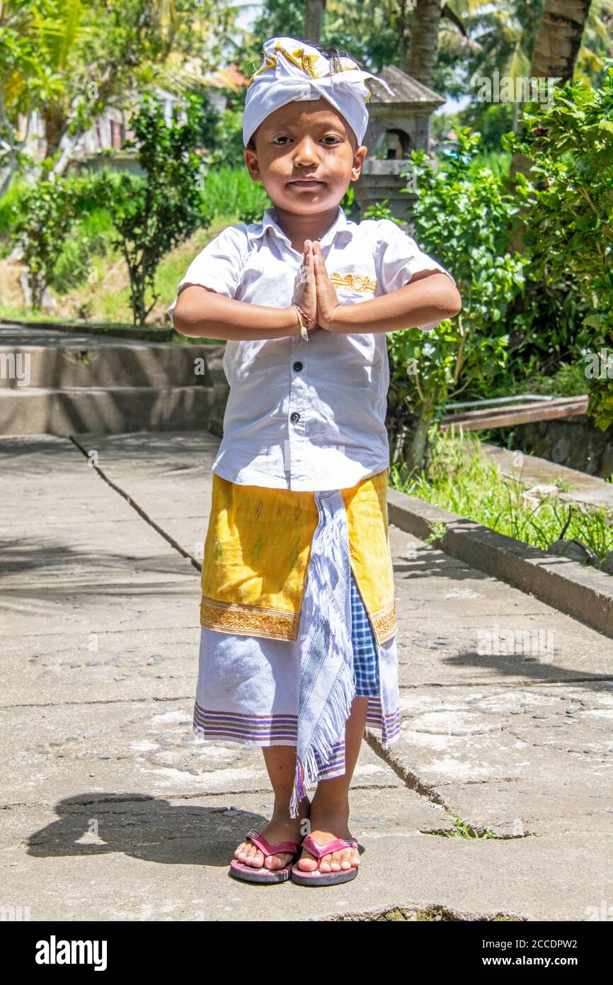 Traditional Balinese dress for formal occasions include a sarong tied and kept in place with a songket and a headdress called an Udeng for males. Stock Photo
