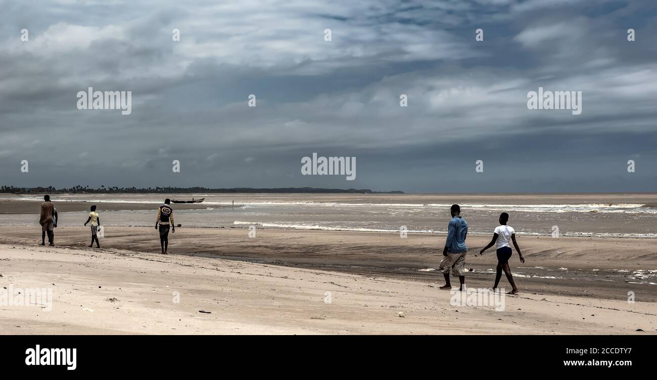 The fishermen walk on the beach on their way and help to pull in fishing nets. Ghana Shama beach located outside Takoradi. Stock Photo